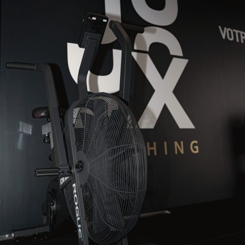 Équipement de cardio-training devant le mur officiel JUX Coaching.